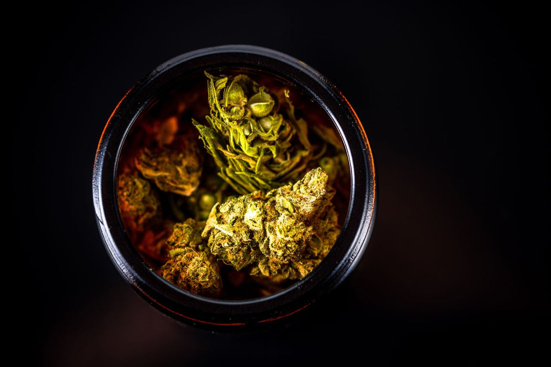 Een pot vol cannabisbloemen en toppen